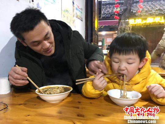 台湾父子品尝阆中牛肉凉面。　张浪 摄