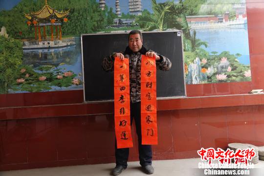 图为村民展示写好的春联。　张帆 摄