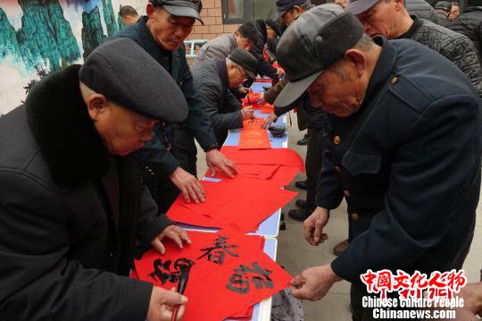 图为给村民写福字。　张帆 摄
