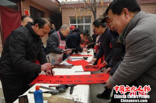 图为王道合给村民们写春联。　张帆 摄