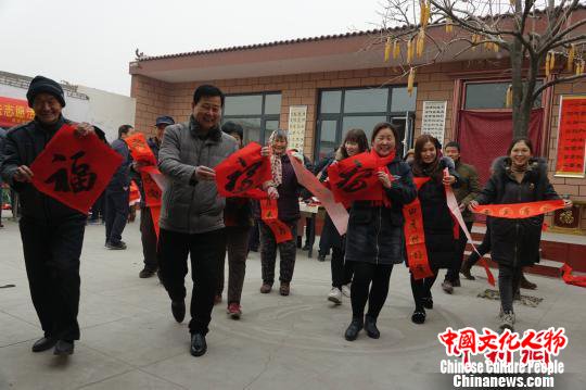 一副春联拉近了乡亲们的感情，王道合家的小院，欢声笑语，年味浓厚。　张帆 摄
