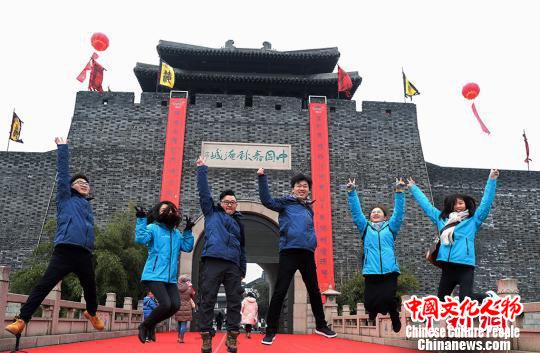 年轻人高高跳起，和巨幅春联合影。　寒单 摄