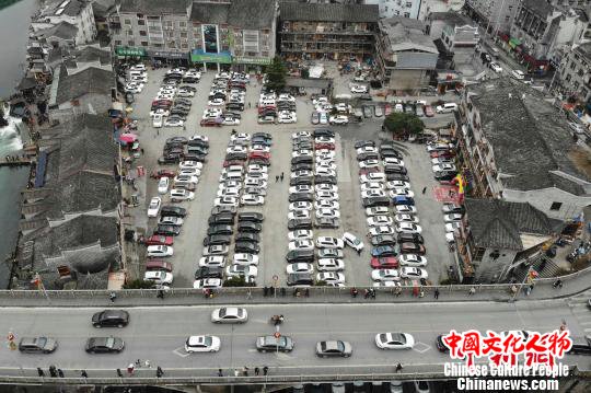 古城内一停车场停满了自驾游的私家车。　杨华峰 摄